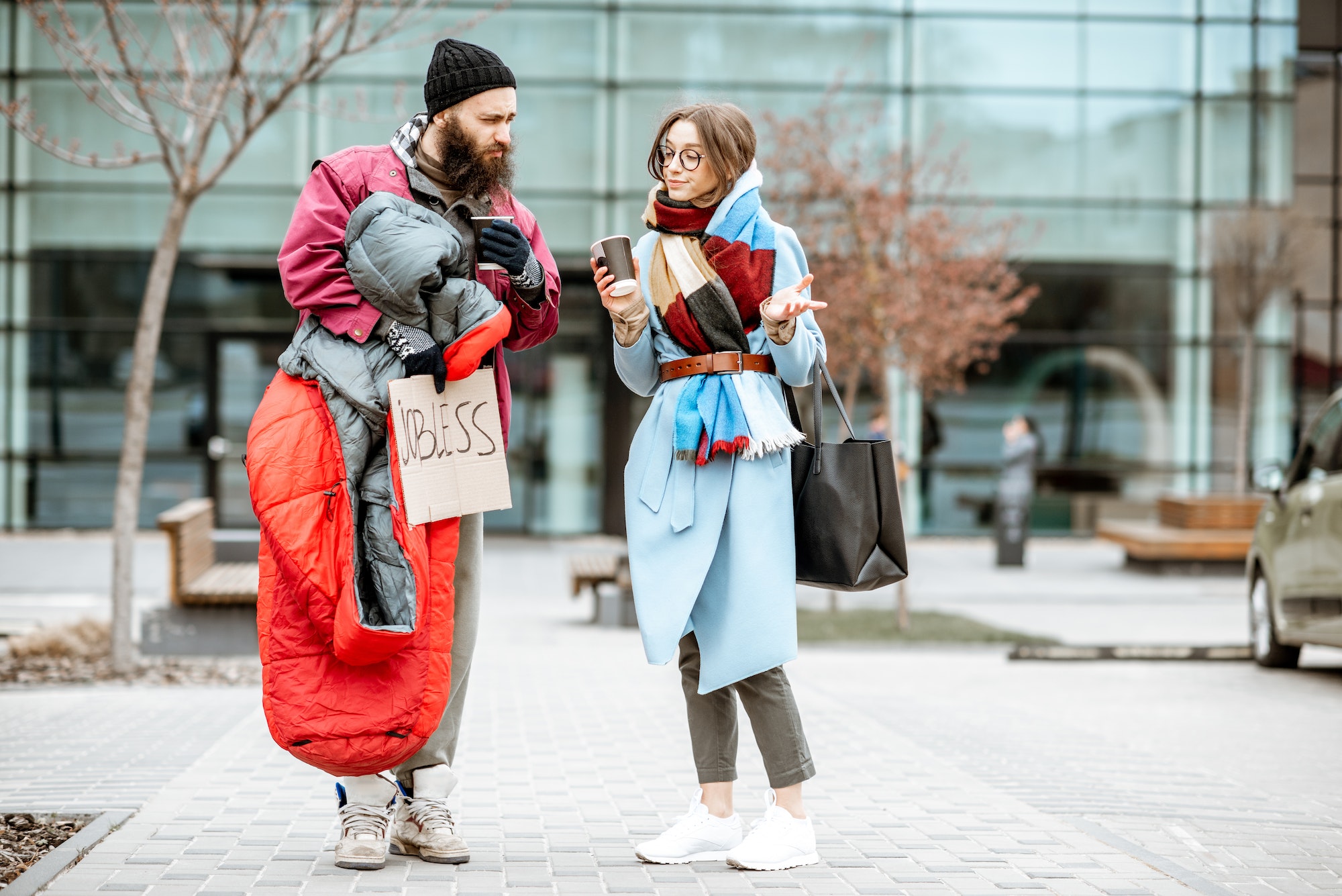 Homeless beggar talking with passing by woman