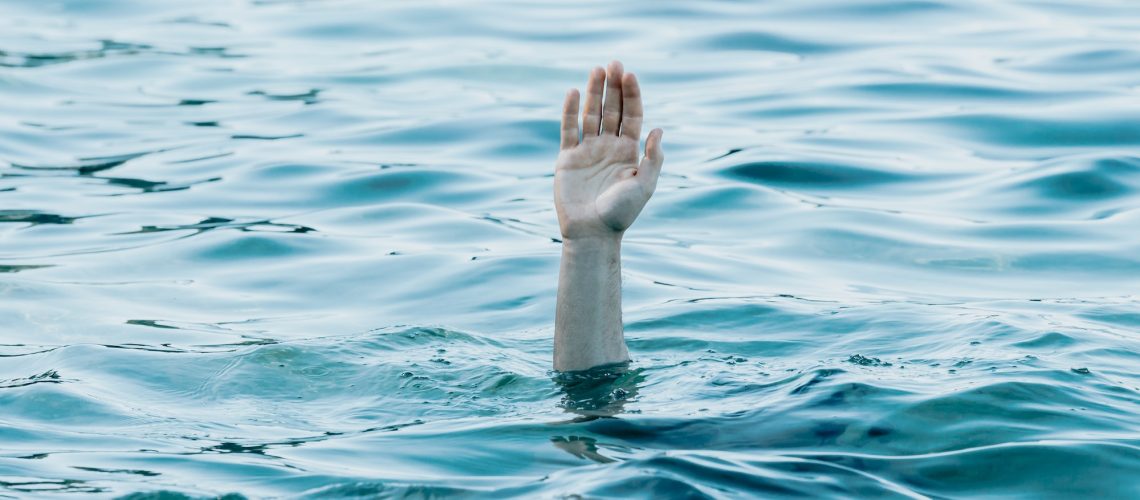 A hand showing out the ocean, rescue and help concept, self care, drown anxiety