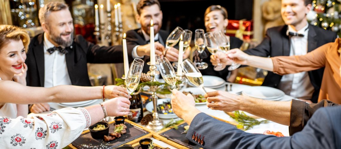 Elegantly dressed people celebrating New Year holiday indoors