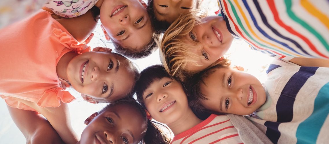 Portrait of schoolkids forming huddle