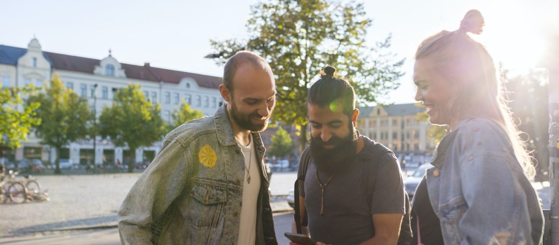 Three friends looking at smartphone