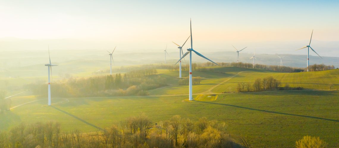 Wind turbines or wind mills farm in the field at sunlight